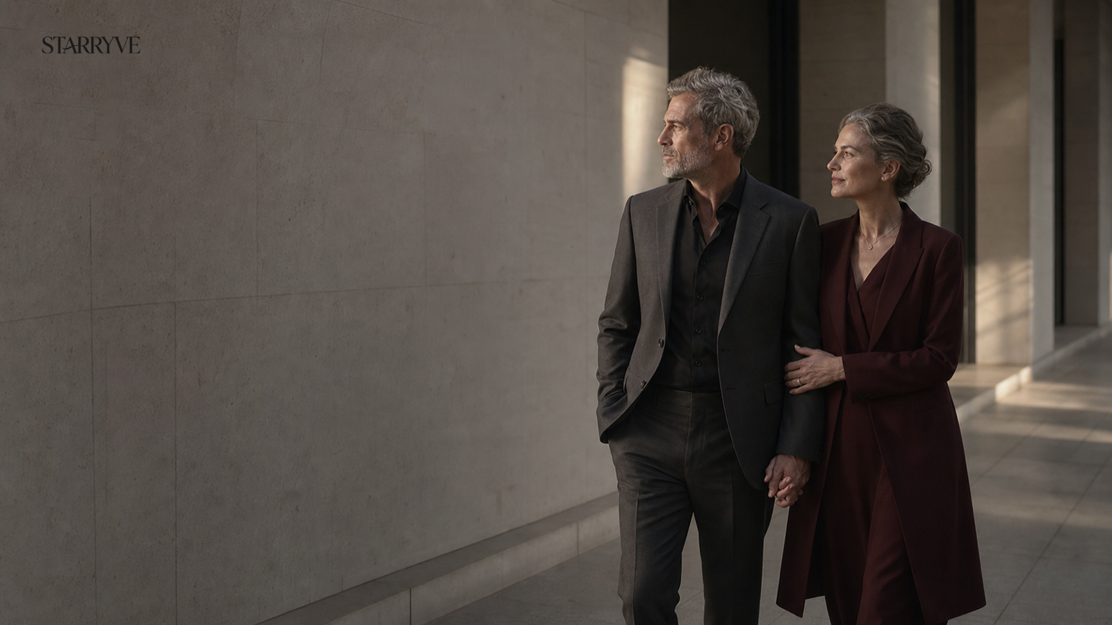 Mature couple holding hands in an elegant stone corridor