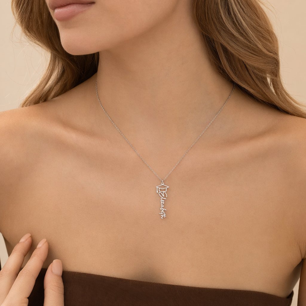 Close-up of the silver graduation cap name necklace at the neckline