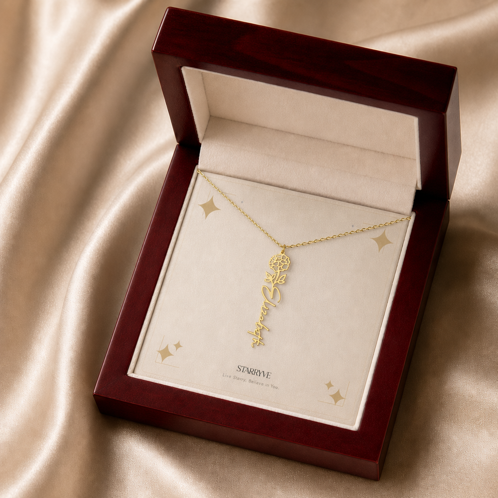 Gold flower name necklace with the October marigold birth flower, shown in a mahogany LED luxury gift box
