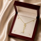 Gold flower name necklace with the December narcissus birth flower, shown in a mahogany LED luxury gift box