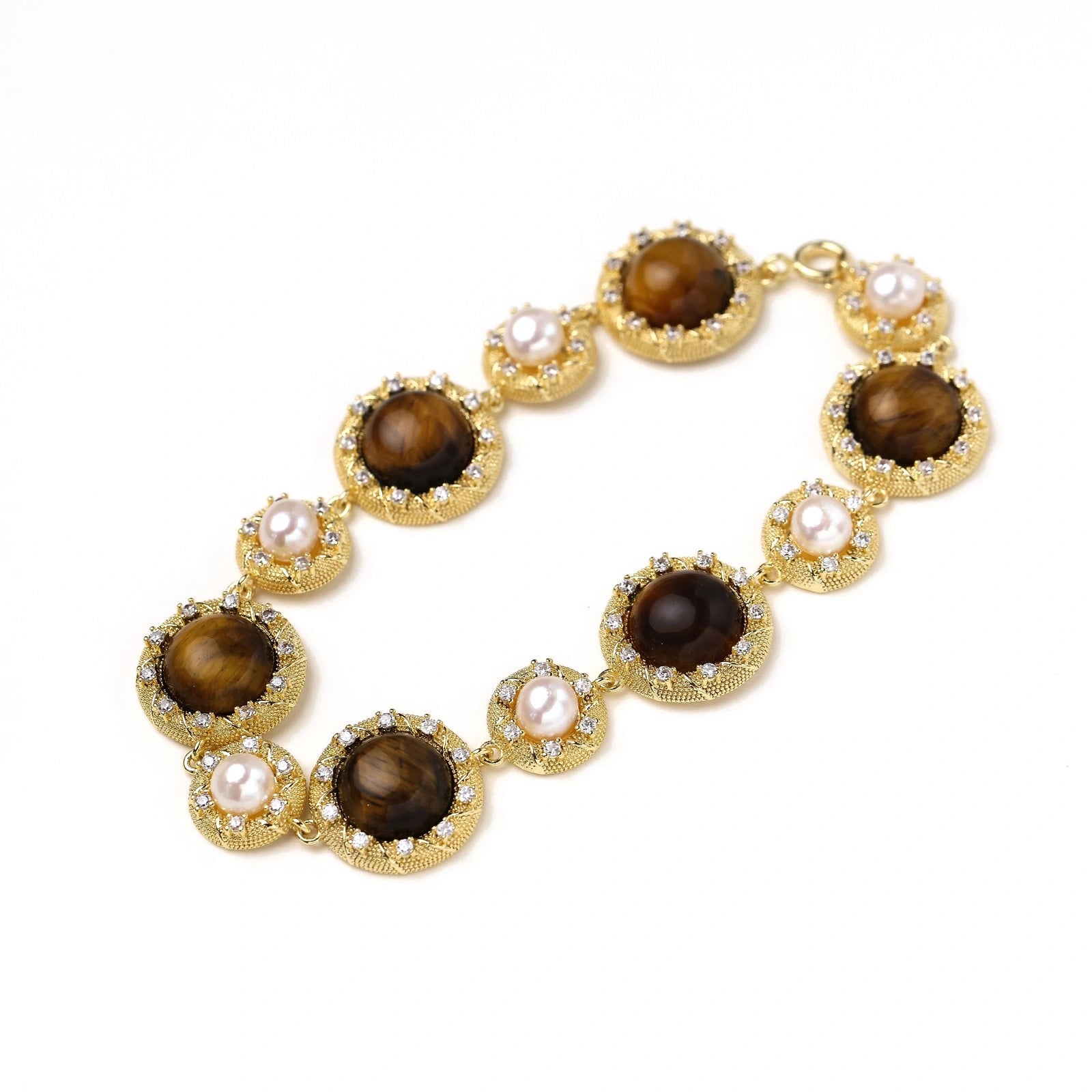Detail view of crystal-framed tiger's eye and pearl medallion