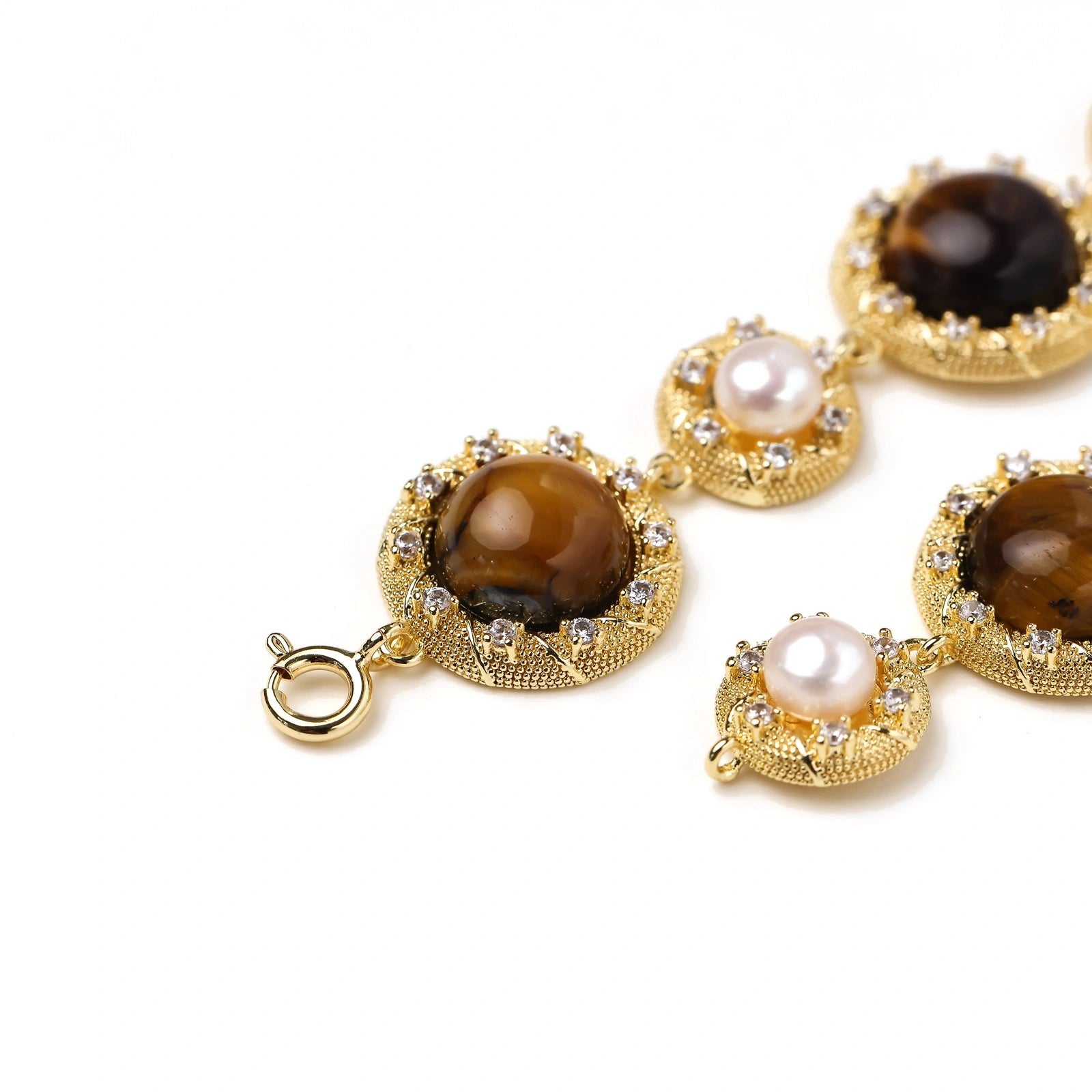 Close-up of a tiger's eye and pearl medallion on the bracelet