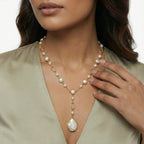 Woman wearing the pearl station lariat necklace in a layered look
