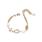 Woman wearing the golden pearl bracelet stacked with other jewelry
