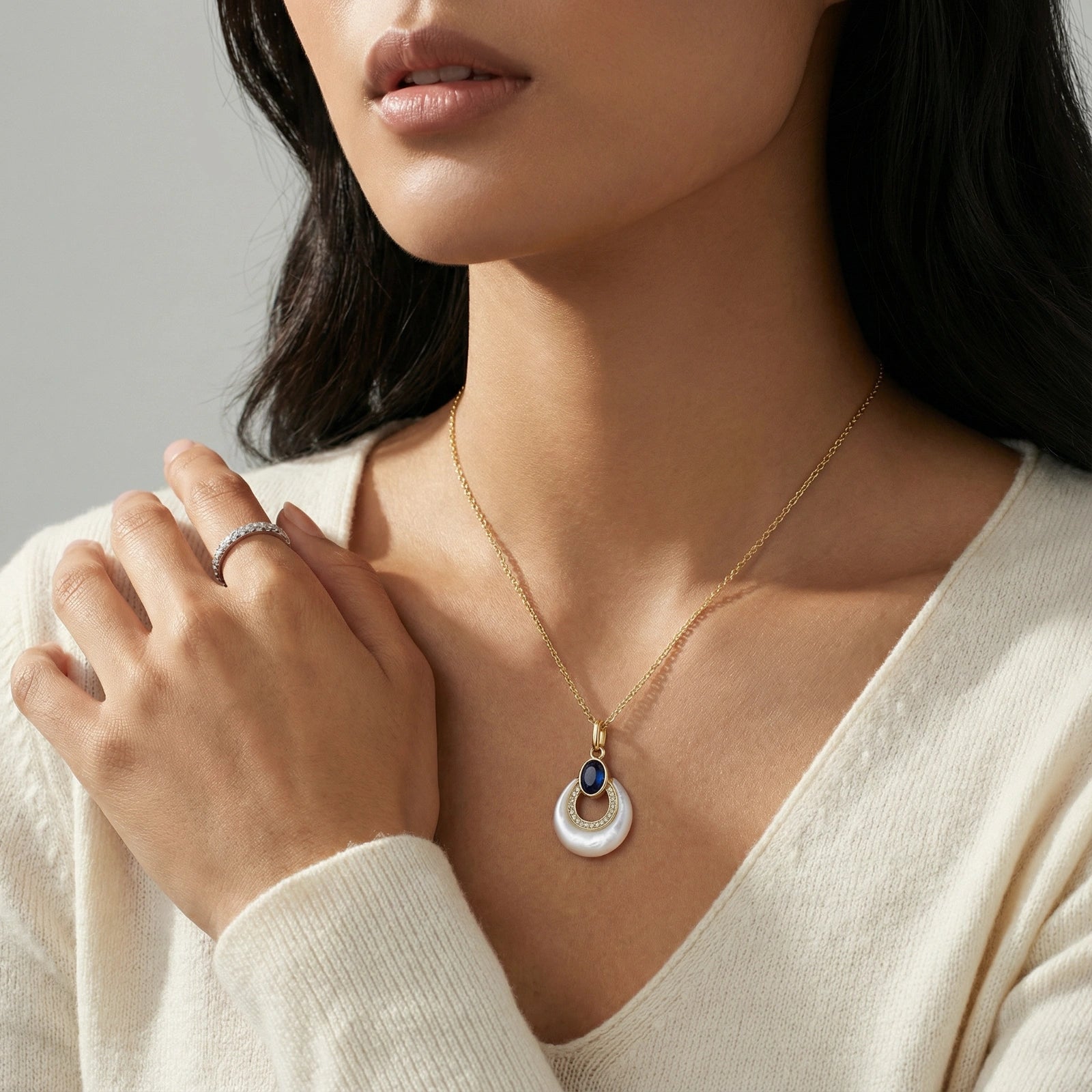 Close-up of the lapis lazuli and mother-of-pearl pendant worn with a white top