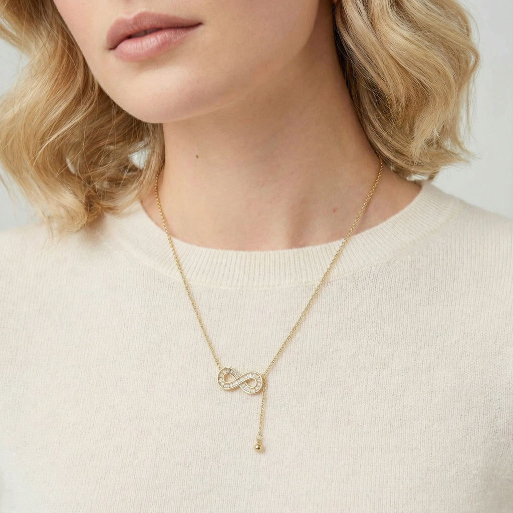 Woman wearing the infinity sparkle necklace with a light top