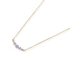 Flat lay of the golden arc necklace on a white background