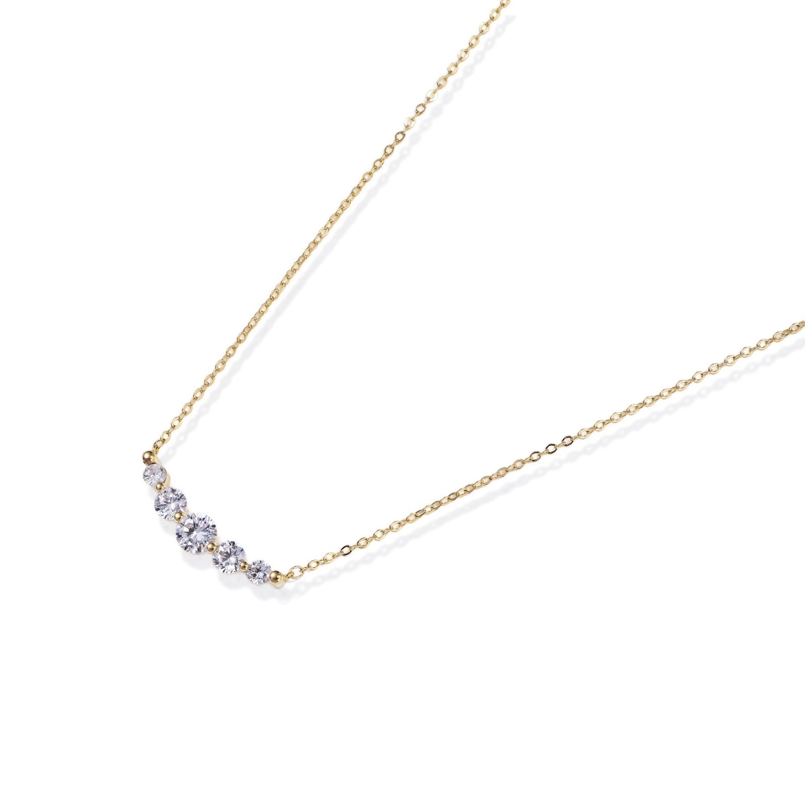 Flat lay of the golden arc necklace on a white background