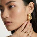 Model wearing Wave Flow Hoop Earrings - Gold Ruffled Texture
