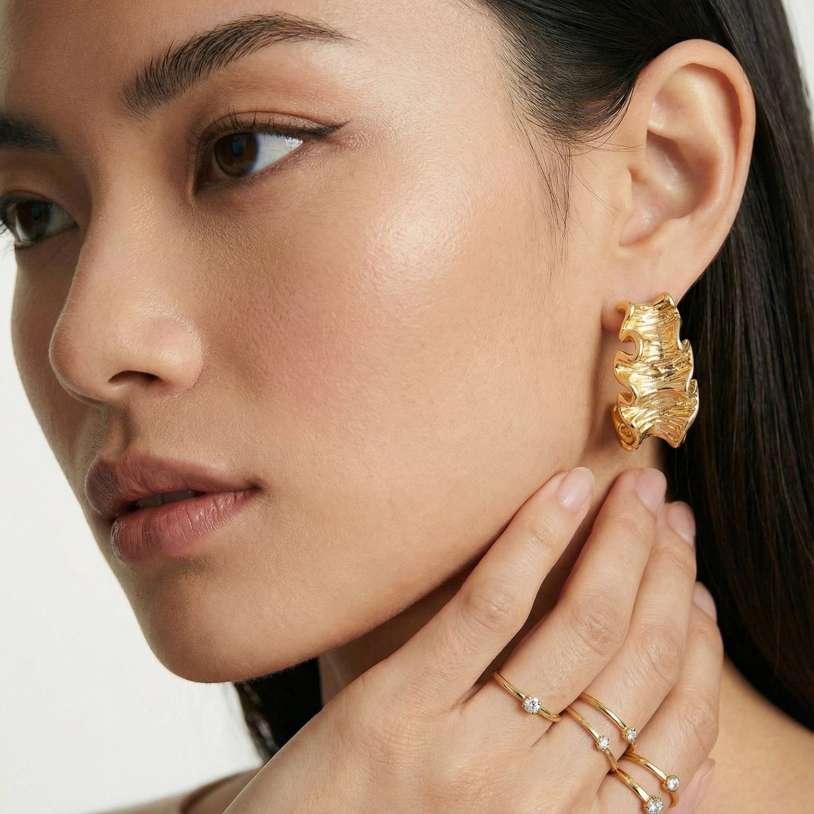 Model wearing Wave Flow Hoop Earrings - Gold Ruffled Texture