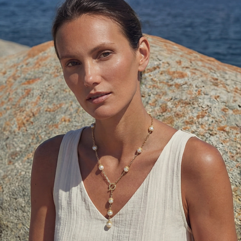 Close-up of the baroque pearl lariat necklace at the neckline