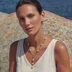 Close-up of the baroque pearl lariat necklace at the neckline