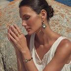 Woman wearing the earth elements bracelet stacked with other bracelets