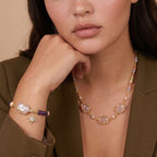 Woman wearing the garden dreams necklace with a hand gesture