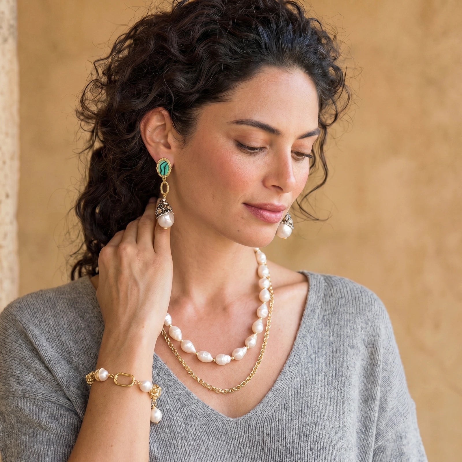 Woman wearing the golden pearl chain bracelet with a light outfit