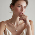 Woman wearing the lumina pearl station necklace with a white top