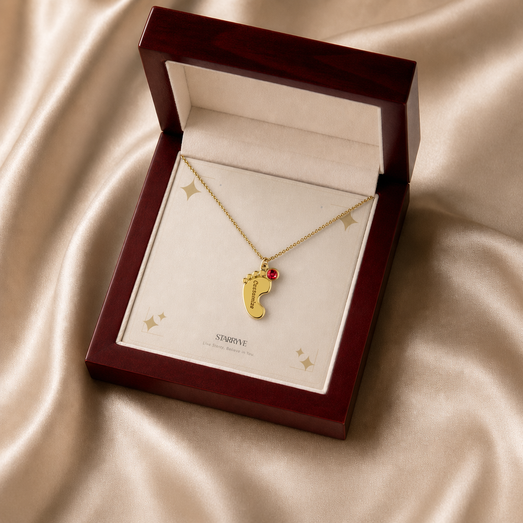 Gold baby feet birthstone necklace displayed in a mahogany LED luxury gift box