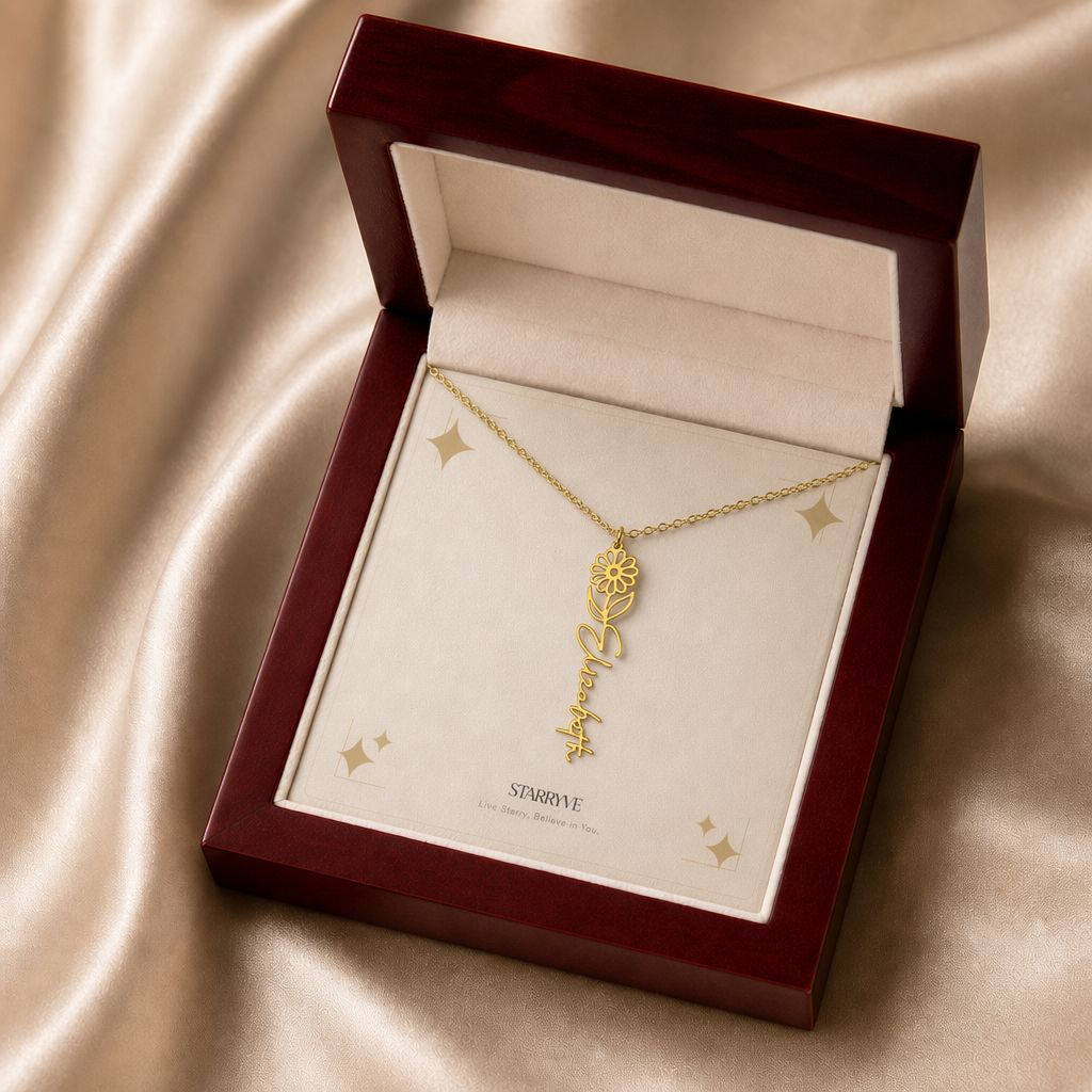 Gold flower name necklace with the April daisy birth flower, shown in a mahogany LED luxury gift box