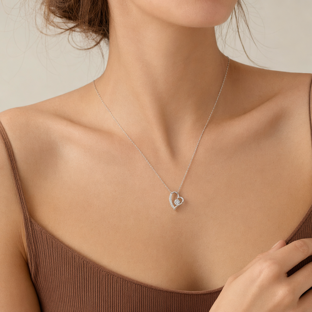 Woman wearing the white gold open heart necklace with a light top