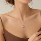 Woman wearing the white gold open heart necklace with a light top