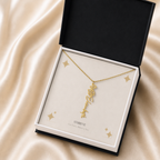 Gold flower name necklace with the May lily of the valley birth flower, shown in a black standard gift box