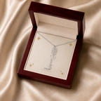 Silver flower name necklace with the August poppy birth flower, shown in a mahogany LED luxury gift box