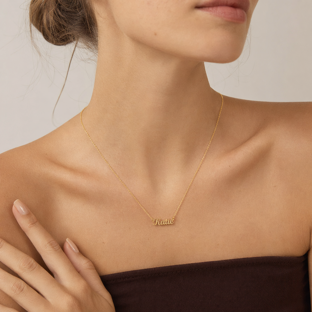 Close-up of the gold custom name necklace at the neckline