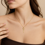 Close-up of the gold graduation cap name necklace at the neckline