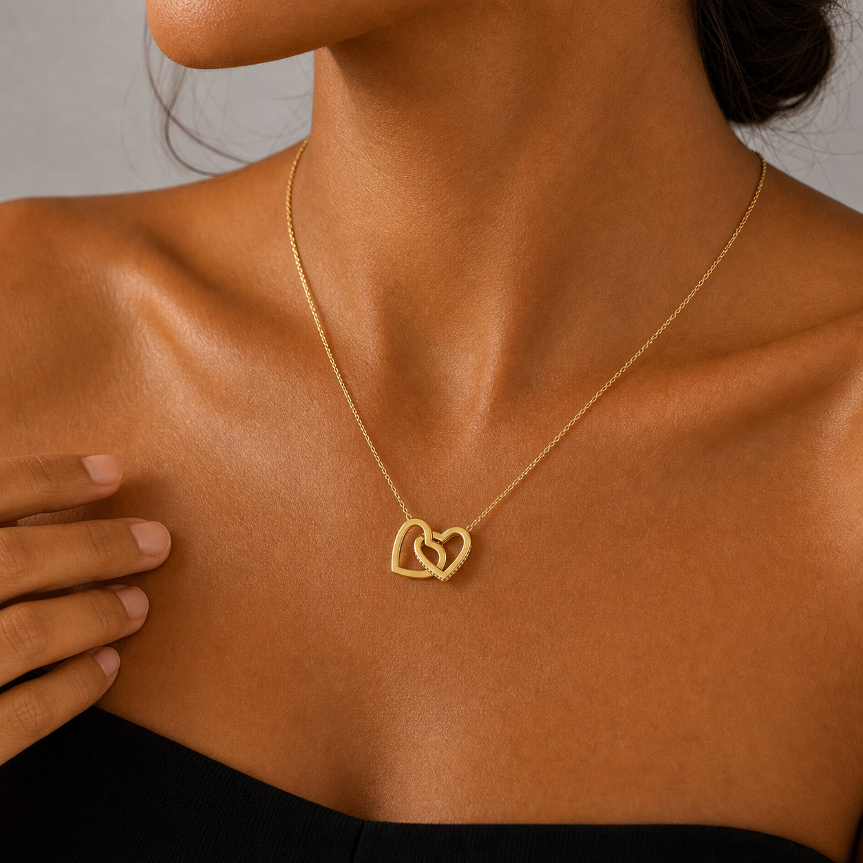 Woman wearing the gold interlocking hearts necklace