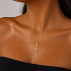 Woman wearing the gold flower name necklace with a black top