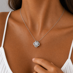 Close-up of the white gold love knot pendant worn with a white top